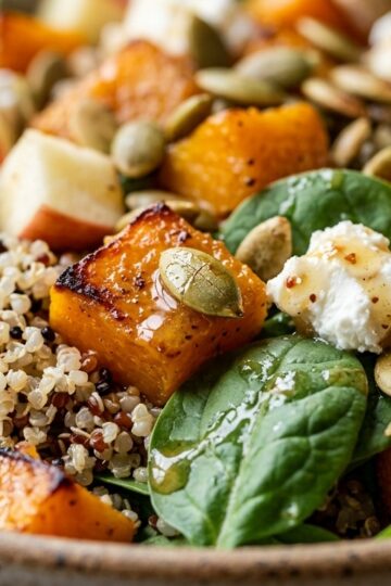 Roasted butternut squash and cranberry quinoa salad with feta in a shallow bowl