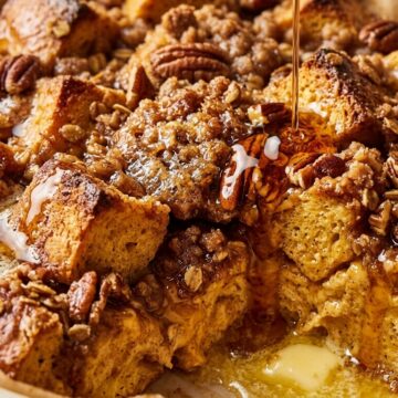 Ultra close-up macro of golden overnight pumpkin spice French toast bake with melted butter and warm maple syrup