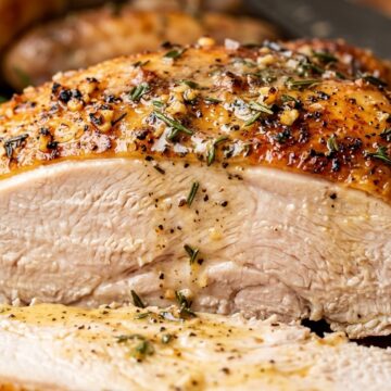 Ultra close-up macro of juicy garlic herb butter roasted turkey breast with golden crispy skin
