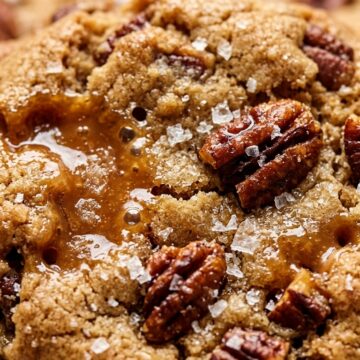 Ultra close-up macro texture of thick chewy brown butter toffee pecan cookies with molten toffee and flaky sea salt
