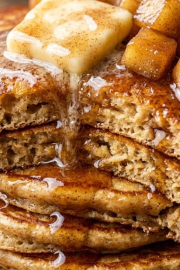 Ultra close-up macro texture of fluffy spiced apple cider pancakes with melting butter and cinnamon syrup