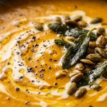 Ultra close-up macro of creamy roasted butternut squash soup with brown butter sage