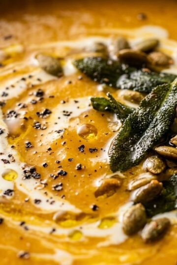Ultra close-up macro of creamy roasted butternut squash soup with brown butter sage