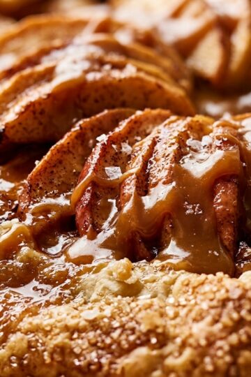 Ultra close-up macro of warm rustic salted caramel apple galette slice with flaky crust